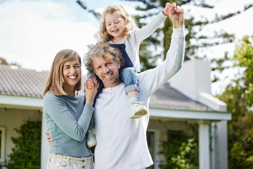 Portrait of a beautiful family having fun with their daughter in their backyard at home